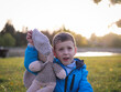 Little boy child portrait in autumn park with soft toy