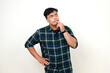 © ArvStd - Confused young adult indonesian man standing with thinking gesture