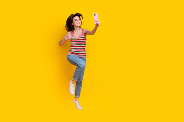 Poster - Full body photo of charming attractive girl wear striped tank fly do selfie on smartphone show like isolated on yellow color background