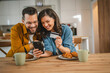 © Miljan Živković - adult happy couple man and woman shopping online hold credit card