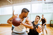 © Marko Geber - Young men playing basketball indoors