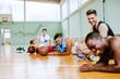 © Marko Geber - Diverse young men doing push ups in basketball gym