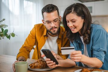 adult happy couple man and woman shopping online hold credit card