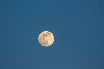 view to the fill moon on blue sky