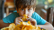 Close-up of Young Boy Eating Potato Chips Snack Time Concept