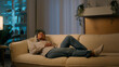 © Yuliia - Tired African American woman in evening night living room lying on cozy sofa falling down on comfortable soft couch relaxed tranquil calm girl dream rest at home relaxing stress free weekend leisure