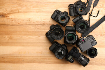 Wall Mural - modern different cameras on wooden table, flat lay. space for text