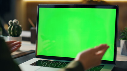 Wall Mural - unknown worker talking green screen laptop at video call workplace close up.