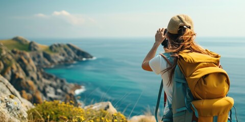 Poster - A woman with a backpack capturing a scenic view of the ocean. Suitable for travel and photography-related content