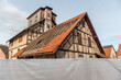 Abbruchreifes historisches Fabrikgebäude mit Fachwerk, Holzaufbau und teilweise abgedecktem Dach