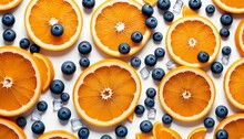 Orange Slices With Ice Cubes And Blueberries On White Background
