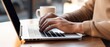© Andrii - Person Typing on Laptop on Wooden Table