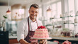 Male pastry chef has baked delicious cakes with pink cream and stands in front of the restaurant. Bakery shop with delicious treats for Valentine's Day for lovers or for a wedding.