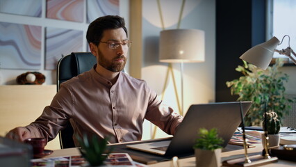 Wall Mural - entrepreneur looking laptop screen working office close up. man drinking coffee.