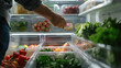 A man puts transparent containers with healthy food in the refrigerator, view from the refrigerator