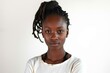 © Tisha - Serious young woman with locs standing against white background