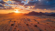 aerial sunrise with shadows over desert terrain.