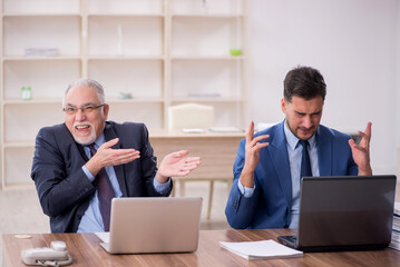 Wall Mural - Two male employees working in the office