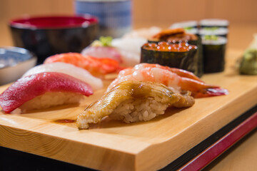 Canvas Print - Japanese food - Sushi set on a wooden plate, selective focus