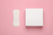 Box with sanitary pads on pink background. Feminine hygiene