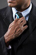 © Image Smith - Close up detail of Indian businessman adjusting his tie.