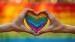 Heart sign of Hands making in front with a rainbow background concept pride day