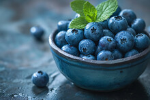 Fresh blueberries in a bowl on a dark rustic background.