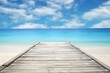 Wooden pier on the beach with turquoise water and blue sky