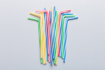 Drinking straws for party on Colored background. Top view of colorful plastic disposable straws for summer cocktails. different straws for juice with copy space