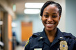 Portrait of smiling african american female police officer in hospital corridor