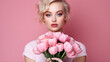 Close-up portrait of an attractive young woman holding a bouquet of tulips on a pink background. Spring banner for Women's Day. Copy space