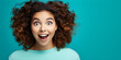 Photo of charming cheerful girl with curly dark hair who is incredibly surprised, amazed with open mouth isolated on turquoise background. Copy space