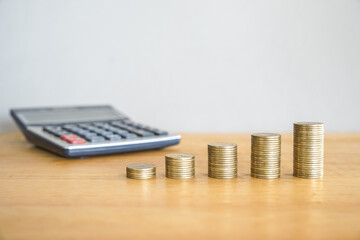 Stacks of coins and calculator on wooden table, business and finance concept