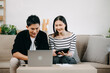 © Nuttapong punna - Asian young attractive couple man and woman use tablet and smartphone online shopping furniture decorate house with carton package move