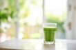 © studioworkstock - cold glass of green juice with morning dew, sunlight behind