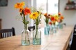 reused glass bottles as flower vases on a dining table