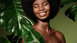 Organic cosmetics concept.  Beauty portrait of young beautiful african american woman with posing with banana leaf curly hair against green exotixc plants background.