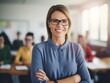 © Svetlana - smiling teacher standing in classroom with arms crossed.
