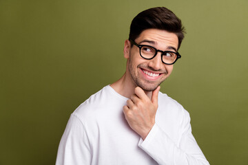 Canvas Print - Portrait of handsome guy wearing white pullover touching chin and classic eyeglasses looking empty space isolated on khaki color background