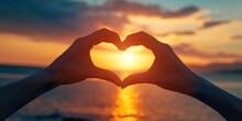 A Close-up Of Hands Forming A Heart Shape With A Beautiful Sunset In The Background - Love And Togetherness Concept Ideal For Romantic Themes And Greeting Cards