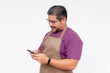 © Mdv Edwards - A cafe shop owner or manager using his cellphone while smiling. Phone food delivery app or contact details concept. Full body photo, Isolated on white background.