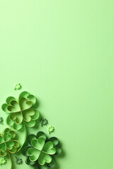 Wall Mural - St Patrick Day concept. Paper art and craft style four-leaf clover on green background. Flat lay, top view, vertical.