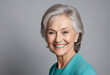 © SR07XC3 - Beautiful older woman smiling near grey wall in close-up portrait.