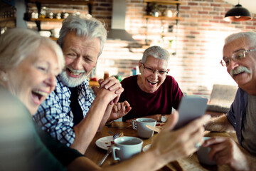 Wall Mural - Group of senior friends enjoying conversation and breakfast together