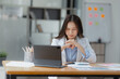 © SOMKID - Asian businesswoman working on tablet with documents and stressed over worked from work in the office, Tired and Overworked businesswoman concept.