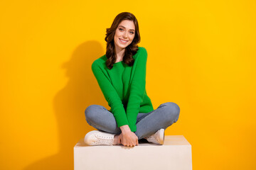 Poster - Full body length photo of nice charming young girlfriend in green jumper and jeans sitting podium isolated on yellow color background