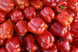 pile of ripe big red peppers at a street market. sweet pepper food background or texture.