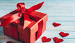 Valentine's Day. Red Gift Box with Ribbon and Red Heart Decorations