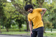 © Tetiana - A young Indian male athlete is standing in the park, bent over and holding his hand behind his back, injured, sprained, feeling terrible pain