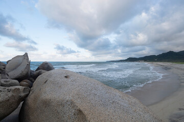 Beautiful colombian tayrona park blue dusk scene with rough sea and cloudy sky at background